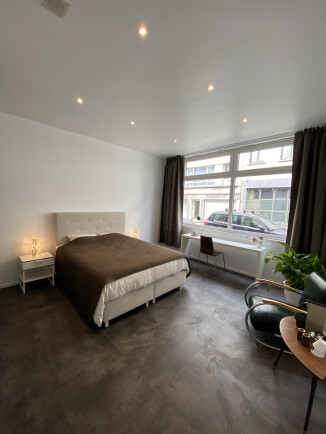 Grote kamer met bureau en kitchenette.