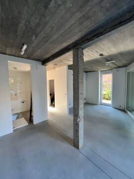 Leefruimte gezien vanuit andere kant. Inde nis komt de keuken. in gat naar badkamer komt ondoorzichtig raam.